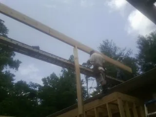 Carpenter setting a ridge beam over a new addition frame — Ice Dam Removal by Roofing Brothers in Beaver Creek