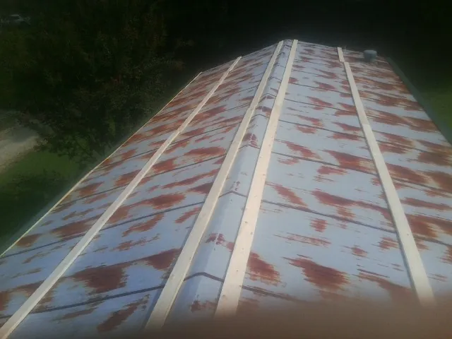 Rusted metal roof panels with new wood purlins before replacement — Storm Damage Roof Repair in Beaver Creek by Roofing Brothers