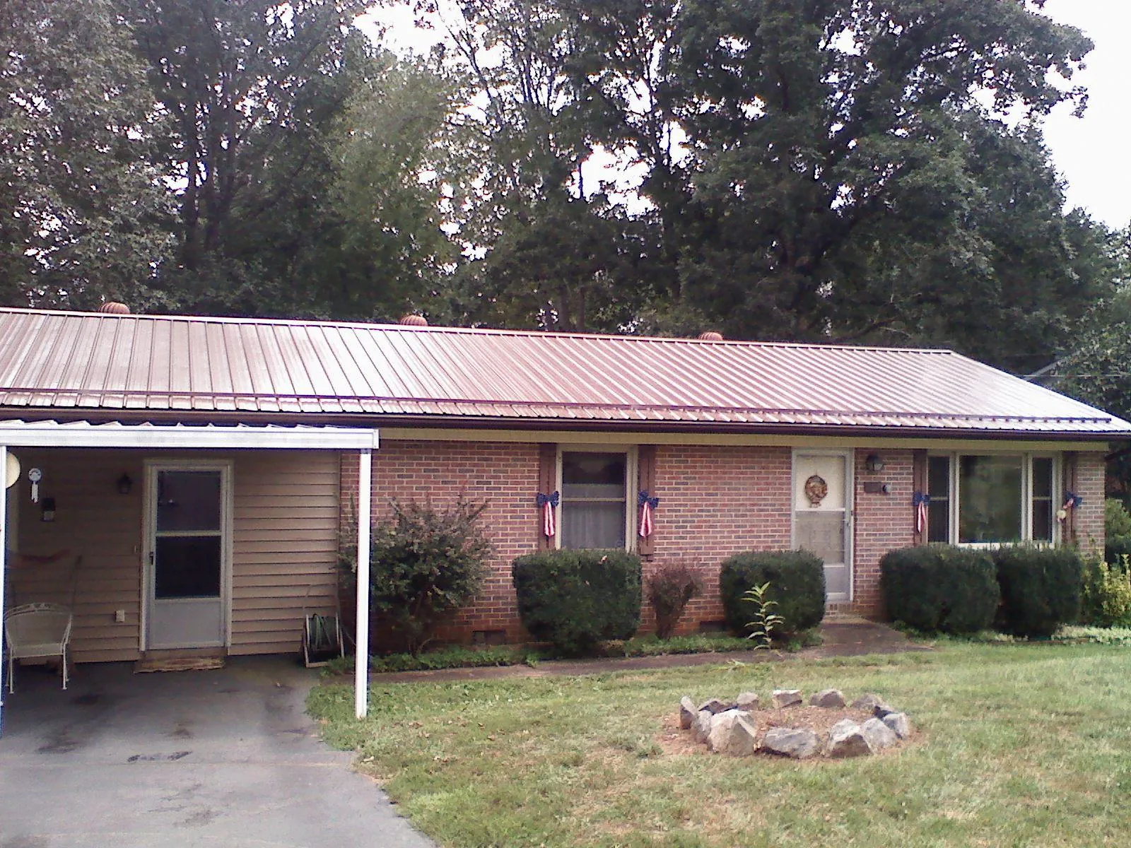 Bronze metal roof and carport on a brick ranch home — Roof Repair work by our crew in Beaver Creek